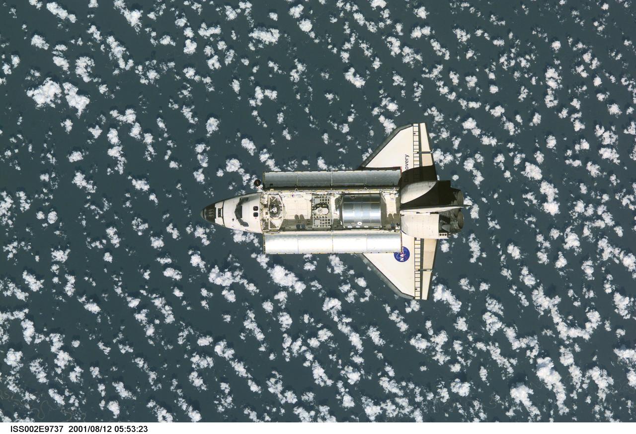 ISS002-E-9737 (12 August 2001) --- View of the Space Shuttle Discovery as it approaches the International Space Station (ISS) during the STS-105 mission. Aboard Discovery are the members of the Expedition Three crew - Frank L. Culbertson, Jr., mission commander, and cosmonauts Vladimir N. Dezhurov and Mikhail Tyurin, flight engineers - who will be replacing the Expedition Two crew that has been living on the ISS for the past five months. Visible in the payload bay of Discovery are the Multipurpose Logistics Module (MPLM) Leonardo, which stores various supplies and experiments to be transferred into the ISS; and the Integrated Cargo Carrier (ICC), which carries the Early Ammonia Servicer (EAS) and two Materials International Space Station Experiment (MISSE) containers. This image was taken with a digital still camera.