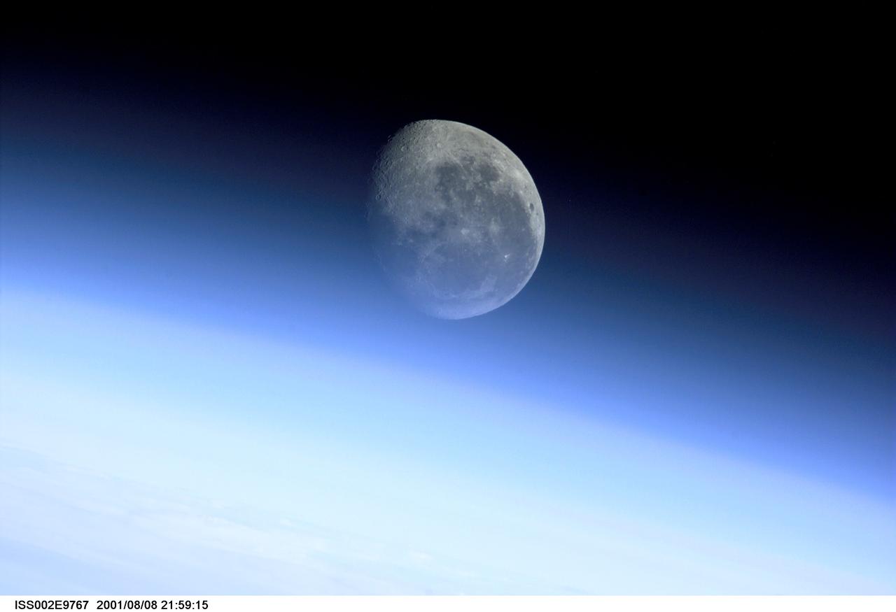 ISS002-E-9767 (8 Aug. 2001) ---  This image, recorded with a digital still camera by one of the Expedition Two crew members onboard the International Space Station,  is a glimpse of the barren moon through the Earth's limb. With no atmosphere, and therefore no limb of its own, the edge of the moon arcs crisply against the backdrop of space. Some of the most breathtaking views of Earth taken from space are those that capture our planet's limb. When viewed from the side, the Earth looks like a flat circle, and the atmosphere appears like a halo around it. This glowing halo is known as the limb. Viewed from satellites, space shuttles, and even the moon, the image of this luminous envelope of gases shielding the life on our planet from the dark, cold space beyond rarely fails to fascinate us.