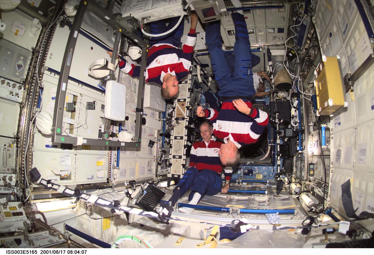 ISS003-E-5165 (17 August 2001) --- Astronauts Frederick W. (Rick) Sturckow (left), STS-105 pilot, Daniel T. Barry and Patrick G. Forrester, both mission specialists, work on various tasks in the Destiny laboratory on the International Space Station (ISS). This image was taken with a digital still camera.