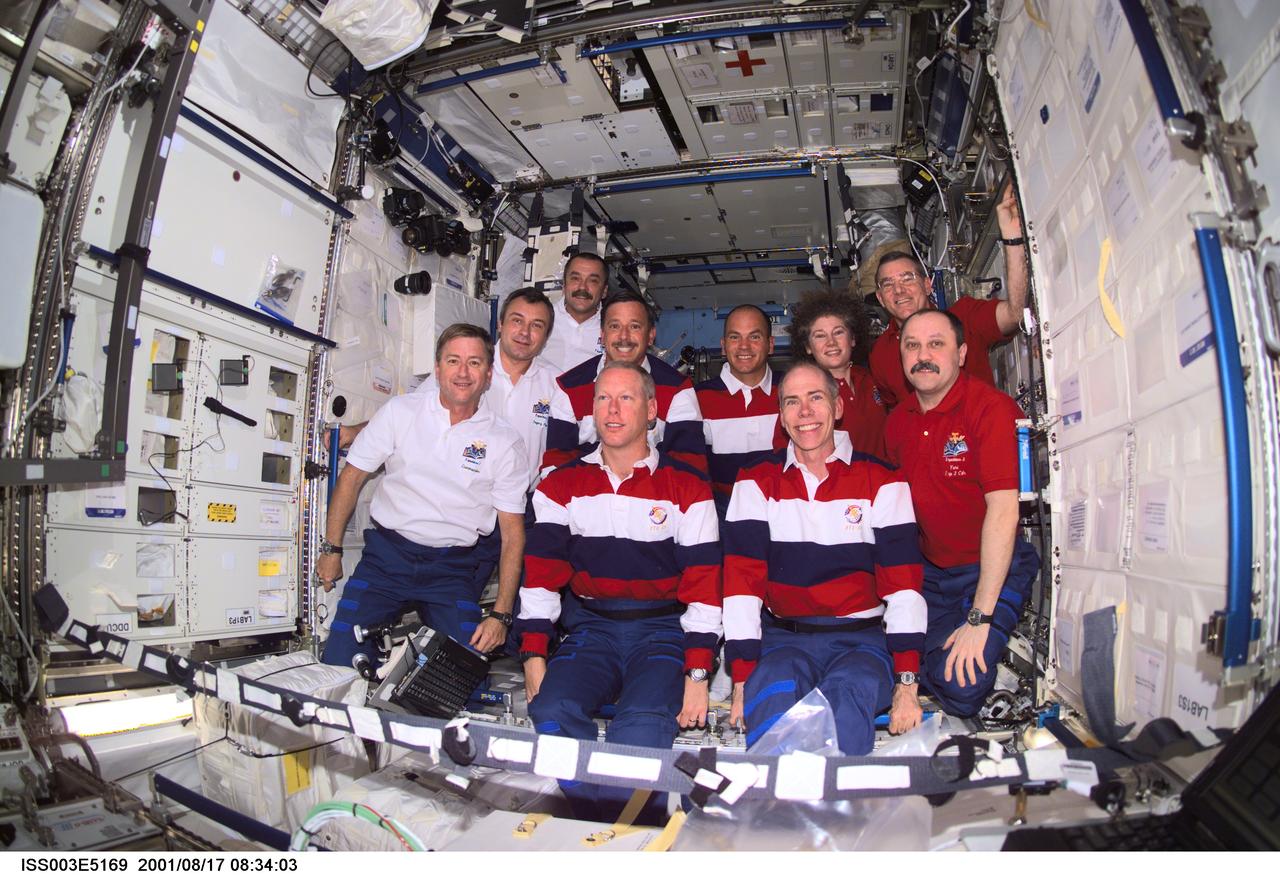 ISS003-E-5169 (17 August 2001) --- The Expedition Three (white shirts), STS-105 (striped shirts), and Expedition Two (red shirts) crews assemble for a group photo in the Destiny laboratory on the International Space Station (ISS). The Expedition Three crew members are, from front to back, Frank L. Culbertson, Jr., mission commander; and cosmonauts Vladimir N. Dezhurov and Mikhail Tyurin, flight engineers; STS-105 crew members are, front row, Patrick G. Forrester and Daniel T. Barry, mission specialists, and back row, Scott J. Horowitz, commander, and Frederick W. (Rick) Sturckow, pilot; Expedition Two crew members are, from front to back, cosmonaut Yury V. Usachev, mission commander, James S. Voss and Susan J. Helms, flight engineers. Dezhurov, Tyurin and Usachev represent Rosaviakosmos. This image was taken with a digital still camera.