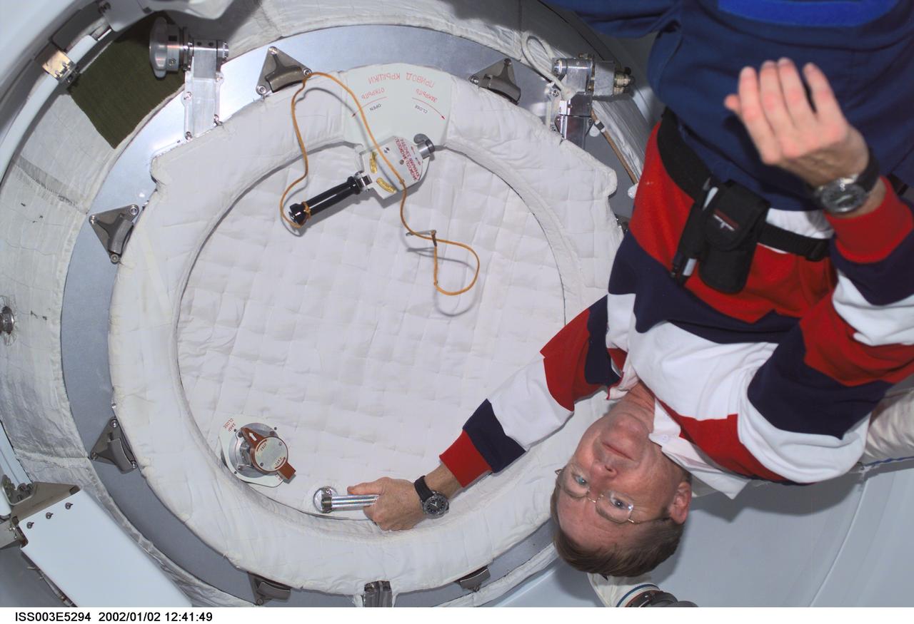 ISS003-E-5294 (August 2001) --- Astronaut Frank L. Culbertson, Jr., Expedition Three commander, closes the hatch in the Pressurized Mating Adapter (PMA2) on the International Space Station (ISS) prior to the separation of the station and the Space Shuttle Discovery. This image was taken with a digital still camera.