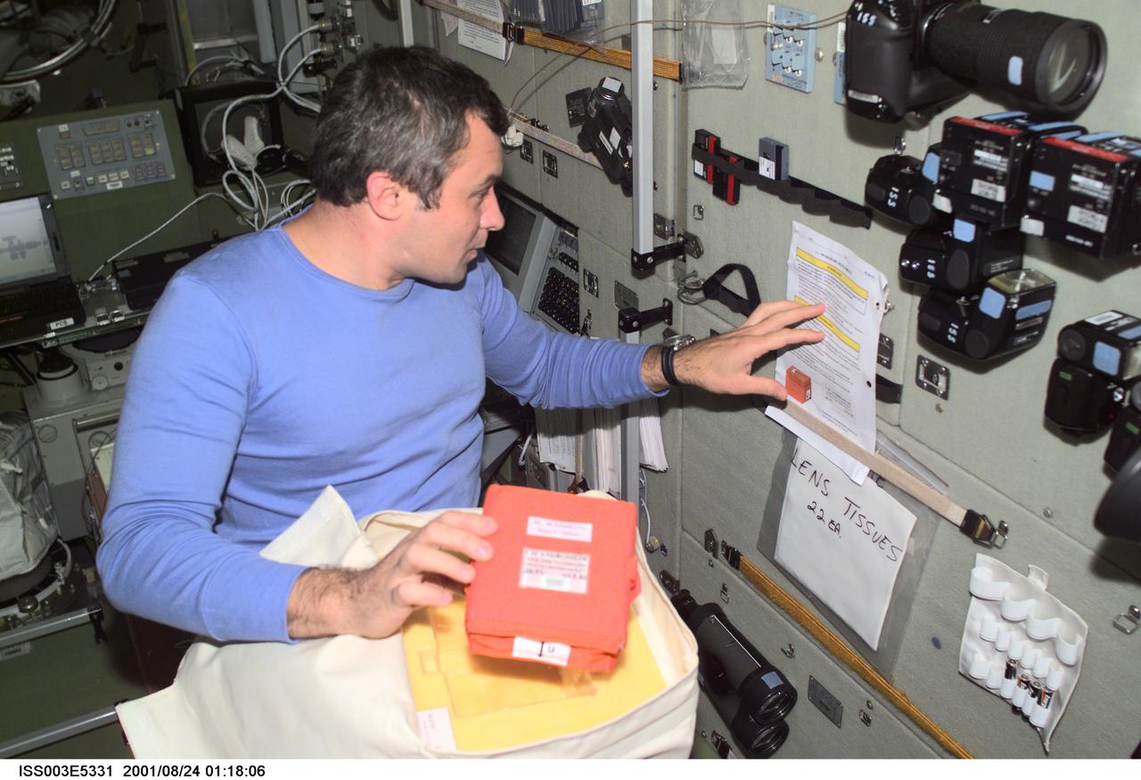 ISS003-E-5331 (24 August 2001) --- Cosmonaut Vladimir N. Dezhurov, flight engineer representing Rosaviakosmos, checks over a list of procedures in the Zvezda Service Module on the International Space Station (ISS). This image was taken with a digital still camera.