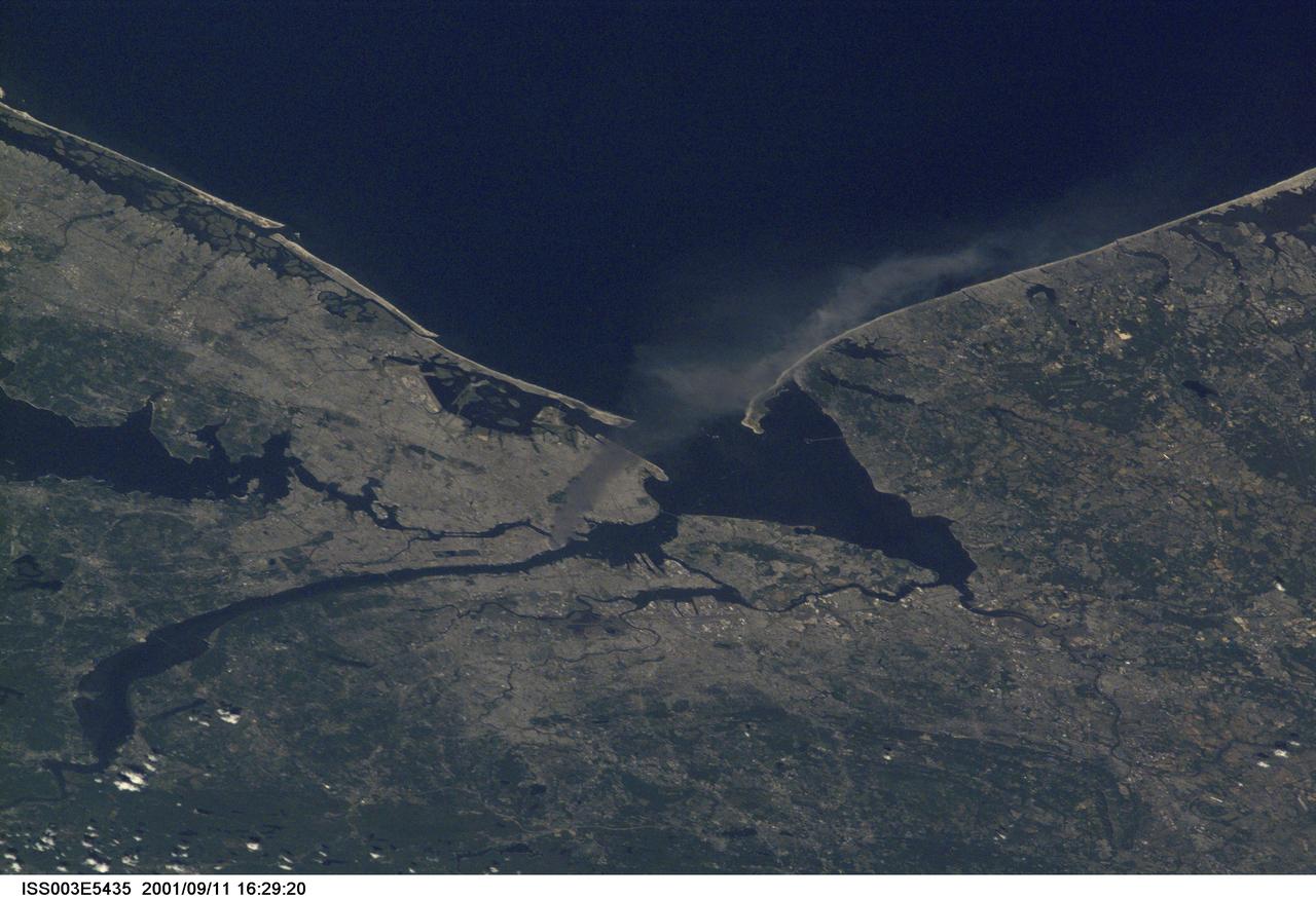ISS003-E-5435 (11 September 2001) --- One of a series of pictures taken of metropolitan New York City (and other parts of New York as well as New Jersey) by one of the Expedition Three crew members onboard the International Space Station (ISS) at various times during the day of September 11, 2001. The image shows a smoke plume rising from the Manhattan area. The orbital outpost was flying at an altitude of approximately 250 miles. The image was recorded with a digital still camera. Please note: The date identifiers on some frames (other than those that indicate Sept. 11, 2001) are not accurate due to a technical problem with one of the Expedition Three cameras.