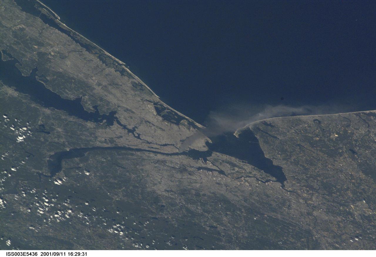 ISS003-E-5436 (11 September 2001) --- One of a series of pictures taken of metropolitan New York City (and other parts of New York as well as New Jersey) by one of the Expedition Three crew members onboard the International Space Station (ISS) at various times during the day of September 11, 2001. The image shows a smoke plume rising from the Manhattan area. The orbital outpost was flying at an altitude of approximately 250 miles. The image was recorded with a digital still camera. Please note: The date identifiers on some frames (other than those that indicate Sept. 11, 2001) are not accurate due to a technical problem with one of the Expedition Three cameras.