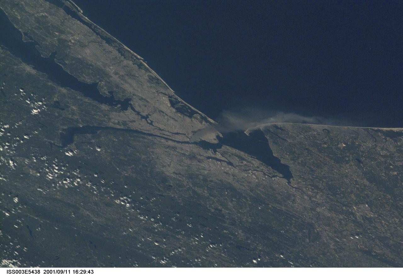 ISS003-E-5438 (11 September 2001) --- One of a series of pictures taken of metropolitan New York City (and other parts of New York as well as New Jersey) by one of the Expedition Three crew members onboard the International Space Station (ISS) at various times during the day of September 11, 2001. The image shows a smoke plume rising from the Manhattan area. The orbital outpost was flying at an altitude of approximately 250 miles. The image was recorded with a digital still camera. Please note: The date identifiers on some frames (other than those that indicate Sept. 11, 2001) are not accurate due to a technical problem with one of the Expedition Three cameras.
