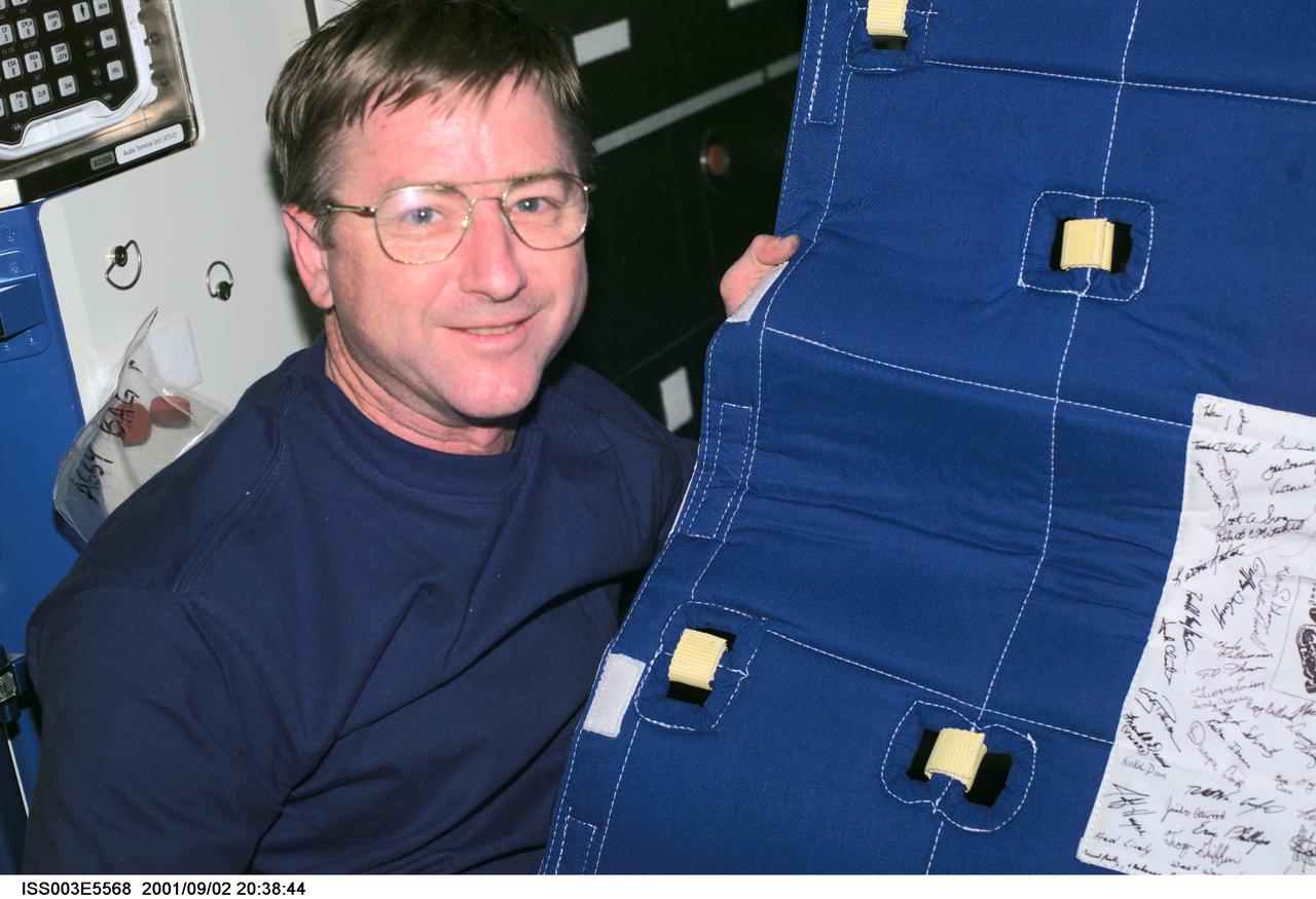 ISS003-E-5568 (2 September 2001) --- Astronaut Frank L. Culbertson, Jr., Expedition Three mission commander, assembles the Temporary Sleep Station (TESS) in the U.S. Laboratory.