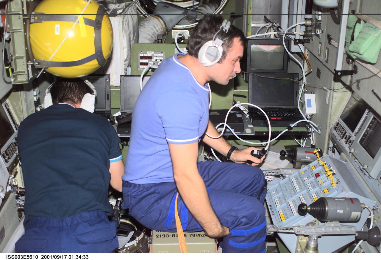 ISS003-E-5610 (17 September 2001) --- Cosmonaut Mikhail Tyurin (left) works with a laptop computer while cosmonaut Vladimir Dezhurov works at the Simvol-Ts workstation in the Zvezda Service Module.  Tyurin and Dezhurov are Expedition Three flight engineers and represent Rosaviakosmos