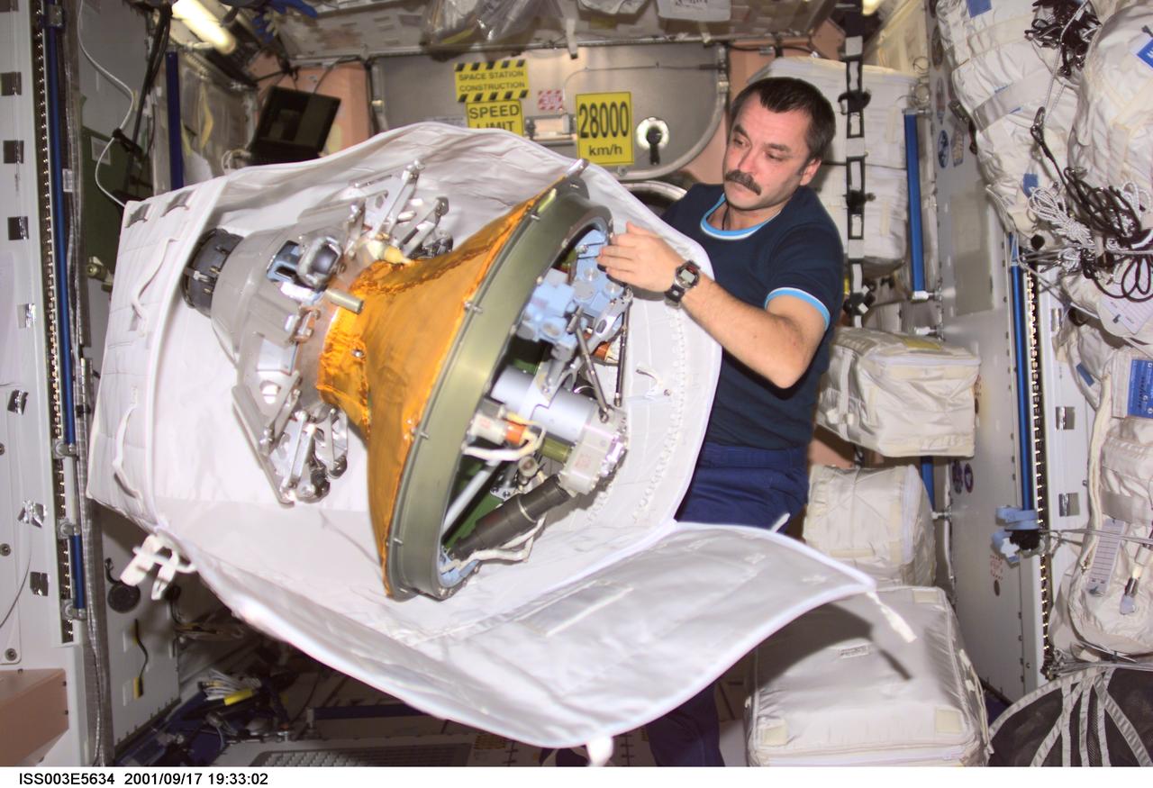 ISS003-E-5634 (17 September 2001) --- Cosmonaut Mikhail Tyurin, Expedition Three flight engineer, packs the docking probe in a stowage bag in Unity.  The docking probe successfully guided the arrival of the Russian-built Pirs docking compartment to the International Space Station (ISS).  Tyurin represents Rosaviakosmos.