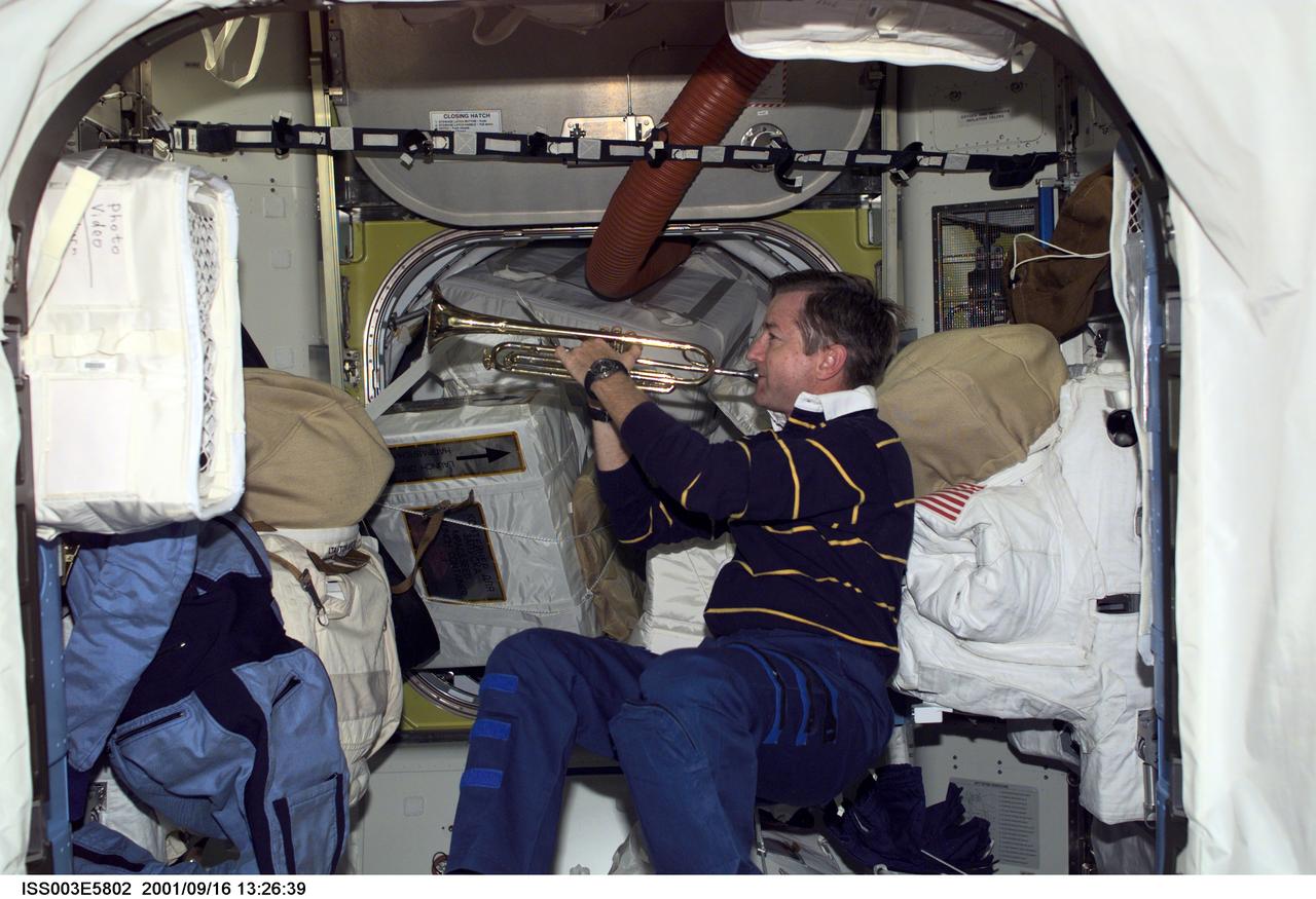 ISS003-E-5802 (16 September 2001) --- Astronaut Frank L. Culbertson, Jr., Expedition Three mission commander, takes a brief timeout from a busy day to play his trumpet in the Quest Airlock on the International Space Station (ISS). This image was taken with a digital still camera.