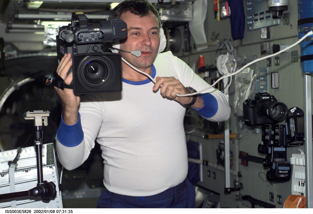ISS003-E-5826 (September 2001) --- Cosmonaut Vladimir N. Dezhurov, Expedition Three flight engineer representing Rosaviakosmos, works with camera equipment in the Zvezda Service Module on the International Space Station (ISS). This image was taken with a digital still camera.
