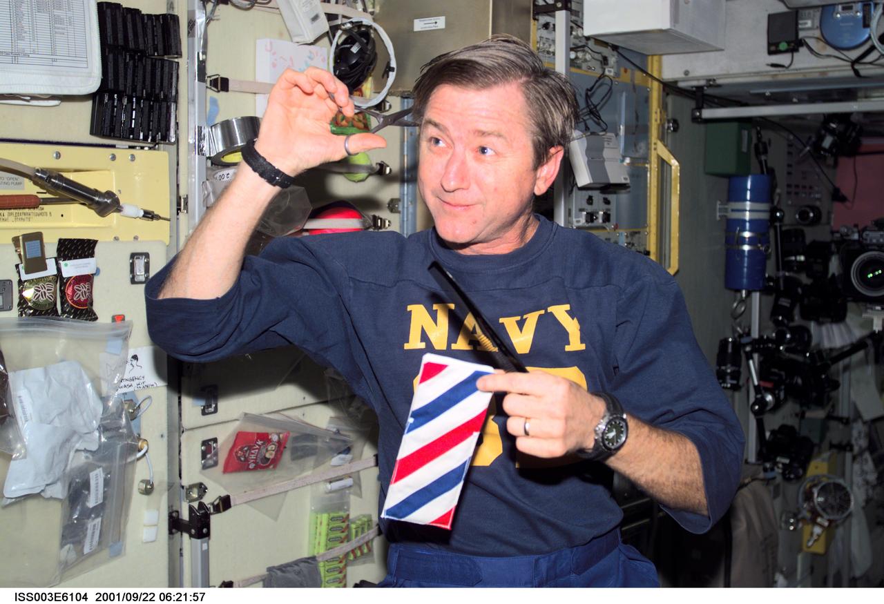 ISS003-E-6104 (22 September 2001) --- Astronaut Frank L. Culbertson, Jr., Expedition Three mission commander, cuts his hair in the Zvezda Service Module on the International Space Station (ISS). This picture was taken with a digital still camera.