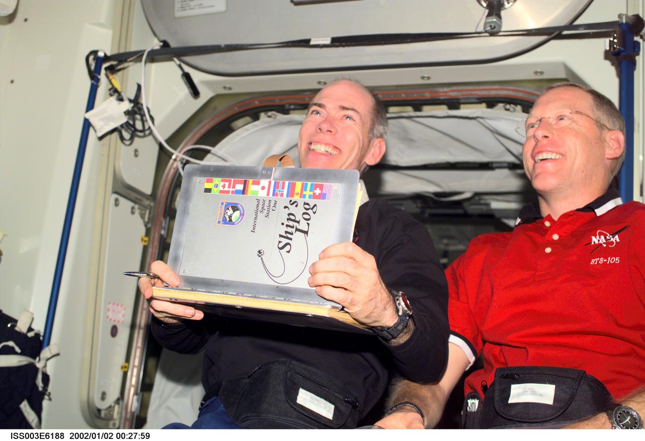 ISS003-E-6188 (August 2001) --- Astronauts Daniel T. Barry (left) and Patrick G. Forrester, both STS-105 mission specialists, add their names to the list of International Space Station (ISS) visitors in the ship&#0146;s log in the Unity node. This image was taken with a digital still camera.