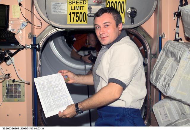 NASA image: Vladimir Dezhurov poses in Node 1 while holding a document