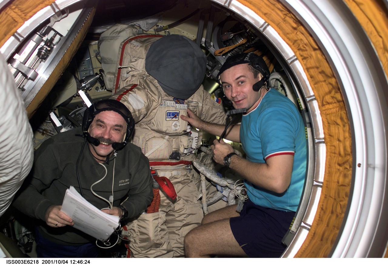 ISS003-E-6218 (4 October 2001) --- Cosmonauts Mikhail Tyurin (left) and Vladimir N. Dezhurov, both Expedition Three flight engineers, prepare the Russian Orlan space suit for an upcoming spacewalk from Pirs Docking Compartment on the International Space Station (ISS). Tyurin and Dezhurov represent Rosaviakosmos. This image was taken with a digital still camera.