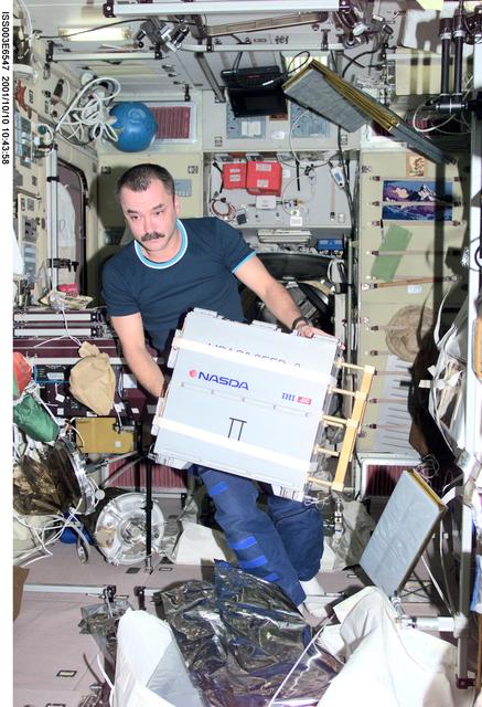 NASA image: Tyurin handles a NASDA exposure experiment case in Zvezda during Expedition Three