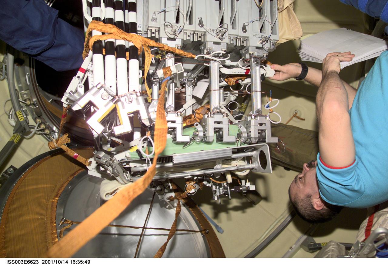 ISS003-E-6623 (14 October 2001) --- Cosmonaut Mikhail Tyurin, Expedition Three flight engineer representing Rosaviakosmos, works with hardware for the Micro-Particles Capturer (MPAC) and Space Environment Exposure Device (SEED) experiment and fixture mechanism in the Zvezda Service Module on the International Space Station (ISS). MPAC and SEED were developed by Japan&#0146;s National Space Development Agency (NASDA), and Russia developed the Fixture Mechanism. This image was taken with a digital still camera.