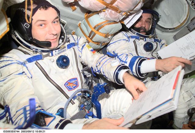 NASA image: Tyurin and Dezhurov are seated in the Soyuz spacecraft during Expedition Three