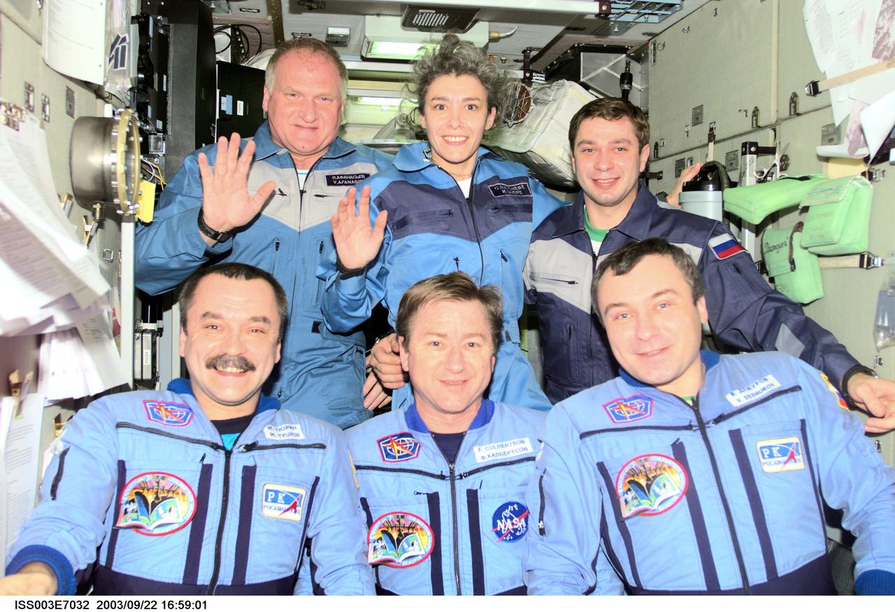 ISS003-E-7032 (23-31 October 2001) --- The Expedition Three crew (bottom) and the Soyuz Taxi crew assemble for a group photo in the Zvezda Service Module on the International Space Station (ISS). The Expedition Three crewmembers are astronaut Frank L. Culbertson, Jr. (center), mission commander, and cosmonauts Mikhail Tyurin (left) and Vladimir N. Dezhurov, both flight engineers. The Soyuz Taxi crewmembers are Commander Victor Afanasyev (left), French Flight Engineer Claudie Haignere, and Flight Engineer Konstantin Kozeev. Tyurin, Dezhurov, Afanasyev, and Kozeev represent Rosaviakosmos. Haignere represents ESA, carrying out a flight program for CNES, the French Space Agency, under a commercial contract with the Russian Aviation and Space Agency. This image was taken with a digital still camera.