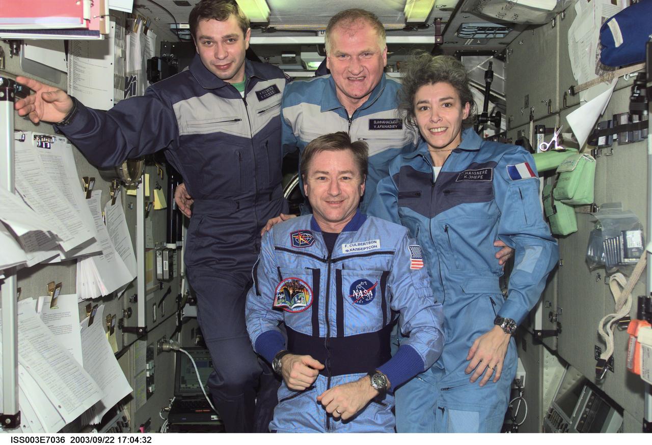 ISS003-E-7036 (23-31 October 2001) --- Astronaut Frank L. Culbertson, Jr. (foreground), Expedition Three mission commander, and the Soyuz Taxi crewmembers assemble for a group photo in the Zvezda Service Module on the International Space Station (ISS). From the left are Flight Engineer Konstantin Kozeev, Commander Victor Afanasyev, and French Flight Engineer Claudie Haignere. Afanasyev and Kozeev represent Rosaviakosmos, and Haignere represents ESA, carrying out a flight program for CNES, the French Space Agency, under a commercial contract with the Russian Aviation and Space Agency. This image was taken with a digital still camera.