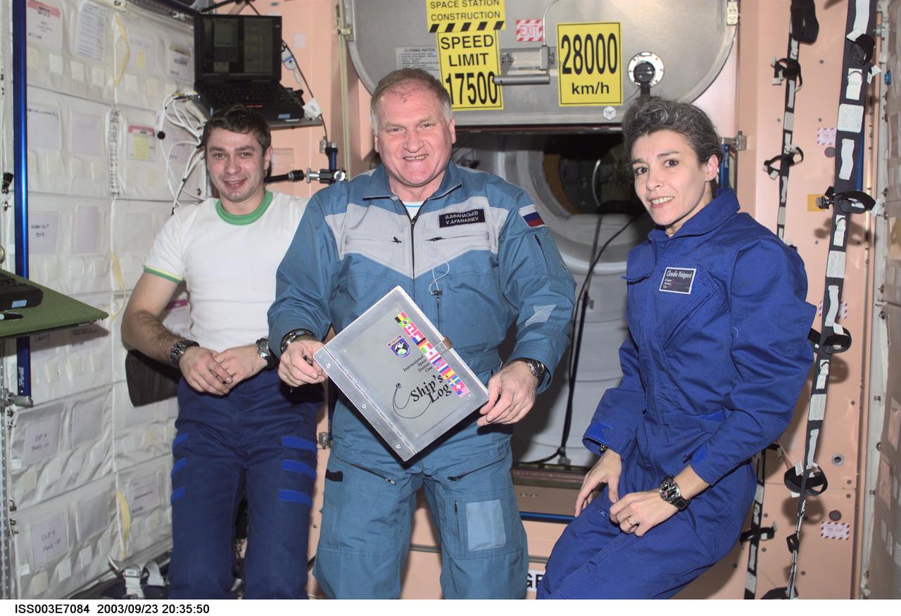 ISS003-E-7084 (23-31 October 2001) --- The Soyuz Taxi crewmembers, Flight Engineer Konstantin Kozeev (left), Commander Victor Afanasyev and French Flight Engineer Claudie Haignere add their names to the list of the International Space Station (ISS) visitors in the ship’s log in the Unity node. Afanasyev and Kozeev represent Rosaviakosmos, and Haignere represents ESA, carrying out a flight program for CNES, the French Space Agency, under a commercial contract with the Russian Aviation and Space Agency. This image was taken with a digital still camera.