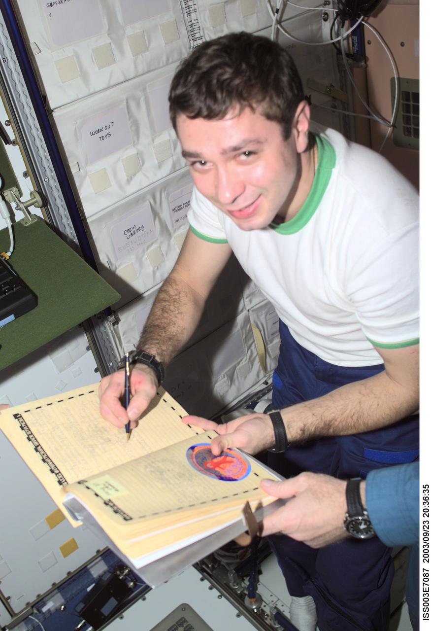 ISS003-E-7087 (23-31 October 2001) --- Flight Engineer Konstantin Kozeev, of the Soyuz Taxi crew, adds his name to the list of the International Space Station (ISS) visitors in the ship&#0146;s log in the Unity node. Kozeev represents Rosaviakosmos. This image was taken with a digital still camera.