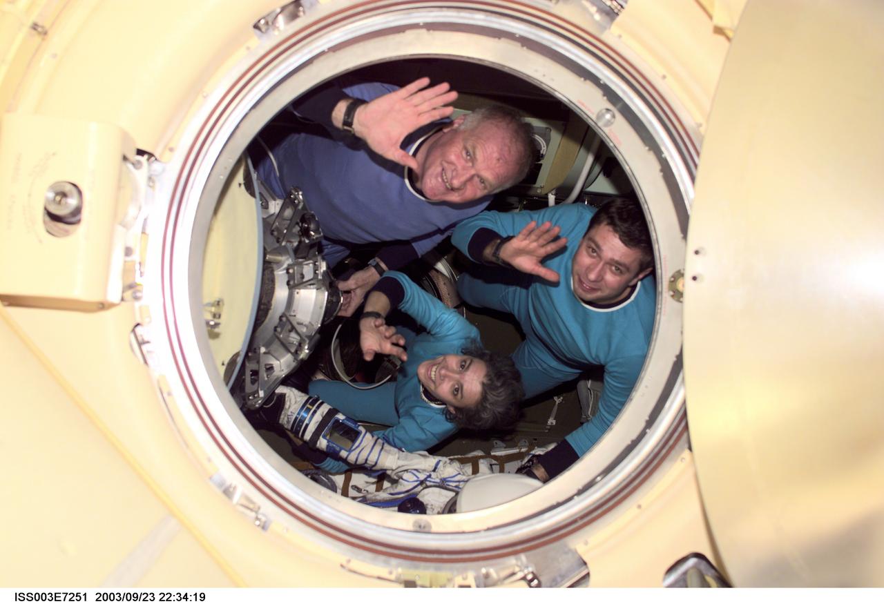 ISS003-E-7251 (23-31 October 2001) --- The Soyuz Taxi crewmembers wave from a Soyuz spacecraft docked to the International Space Station (ISS). Clockwise from the top are Commander Victor Afanasyev, Flight Engineer Konstantin Kozeev and French Flight Engineer Claudie Haignere. Afanasyev and Kozeev represent Rosaviakosmos, and Haignere represents ESA, carrying out a flight program for CNES, the French Space Agency, under a commercial contract with the Russian Aviation and Space Agency. This image was taken with a digital still camera by one of the Expedition Three crew from the nadir docking port on the station.