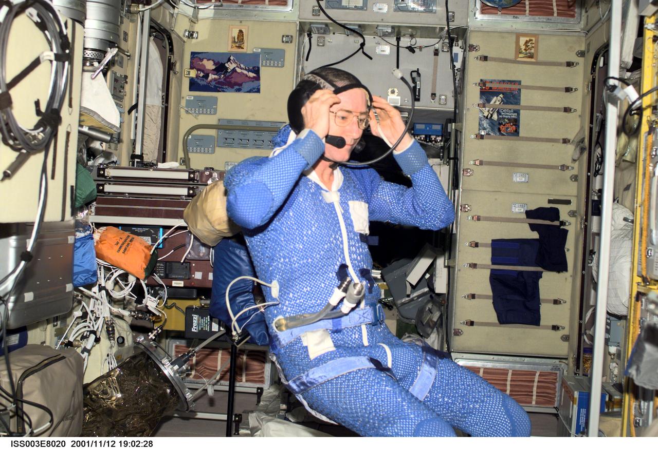 ISS003-E-8020 (12 November 2001) --- Astronaut Frank L. Culbertson, Jr., Expedition Three mission commander, wearing thermal undergarment, adjusts his communication headgear in the Zvezda Service Module on the International Space Station (ISS).  This image was taken with a digital still camera.