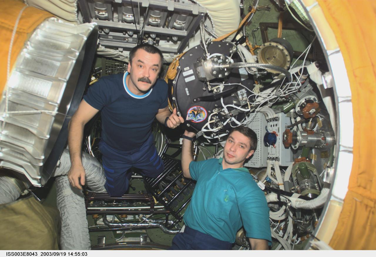 ISS003-E-8043 (23-31 October 2001) --- Cosmonaut Mikhail Tyurin (left), Expedition Three flight engineer, and Soyuz Taxi crewmember, Flight Engineer Konstantin Kozeev, work in the Zvezda Service Module&#0146;s transfer compartment on the International Space Station (ISS). Tyurin and Kozeev represent Rosaviakosmos.
