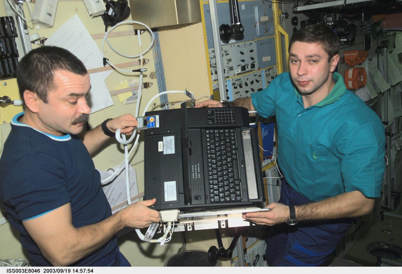 ISS003-E-8046 (23-31 October 2001) --- Cosmonaut Mikhail Tyurin (left), Expedition Three flight engineer, and Soyuz Taxi crewmember, Flight Engineer Konstantin Kozeev work in the Zvezda Service Module on the International Space Station.  Tyurin and Kozeev represent Rosaviakosmos. This image was taken with a digital still camera.