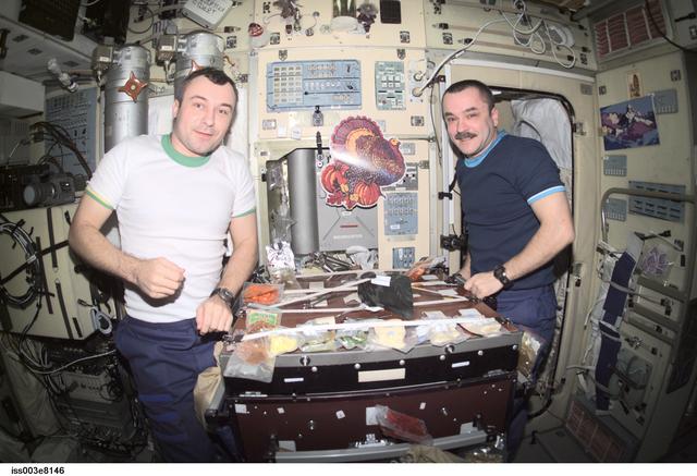 NASA image: Tyurin and Dezhurov eat a Thanksgiving meal in Zvezda during Expedition Three