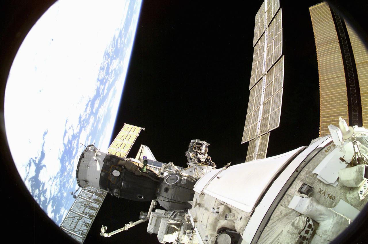 ISS003-E-8279 (7 December 2001) --- One of the Expedition Three crew members aimed a digital still camera through a  window on the Russian segment of the International Space Station (ISS) to record this image of rendezvous operations with the Space Shuttle Endeavour.  With six astronauts and a cosmonaut aboard, Endeavour was very near the point of docking at this point. Viewing of the shuttle in this scene is almost obstructed by the Soyuz vehicle docked above it.