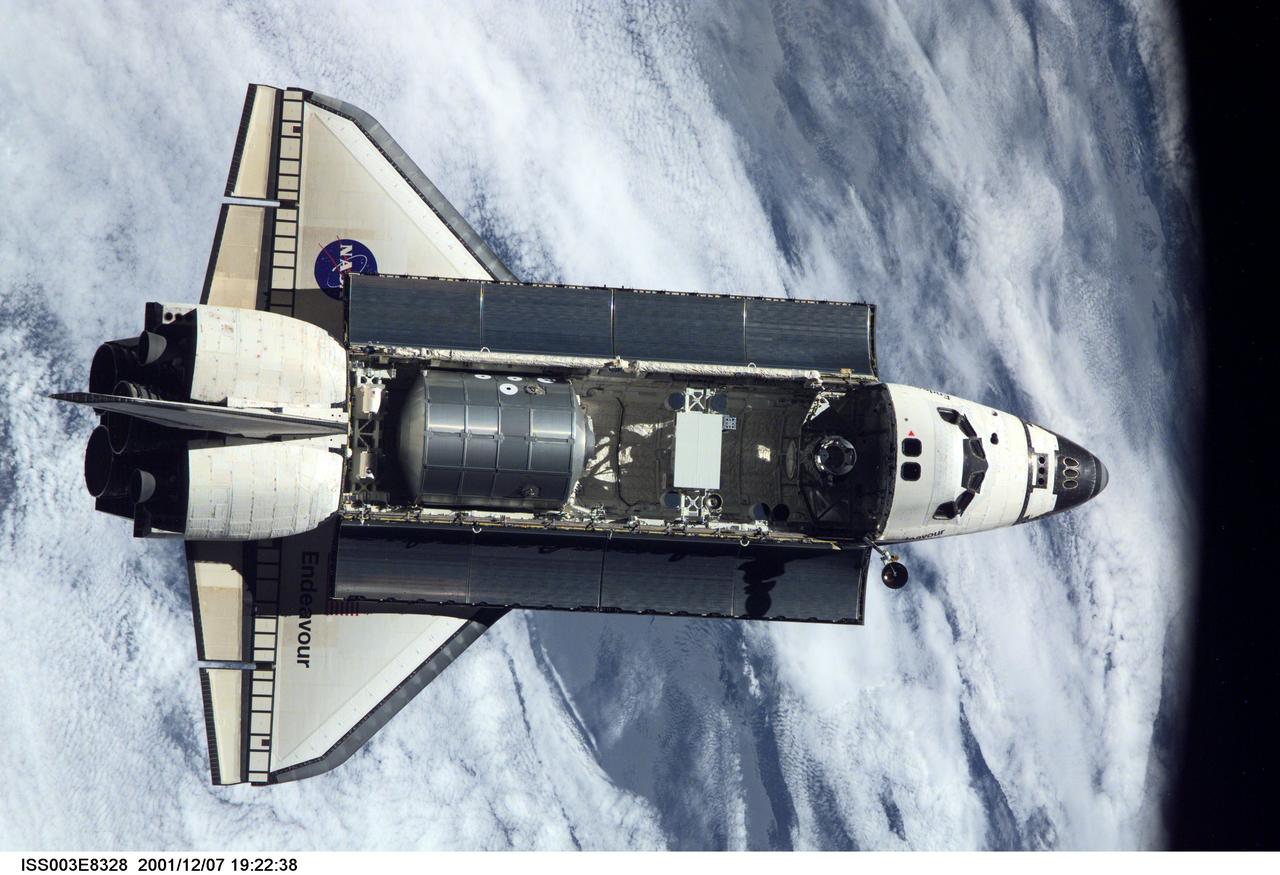 ISS003-E-8328 (7 December 2001) --- The Space Shuttle Endeavour, controlled by the flight crew of STS-108, is backdropped over a large area of cloud cover on Earth as it nears its rendezvous with the International Space Station (ISS). The Raffaello logistics module that is being brought up to the orbiting outpost is clearly visible in Endeavour's cargo bay. Among other activities the Endeavour's mission will include the change out of the station crews. The image was recorded with a digital still camera.