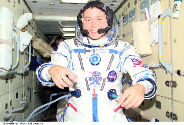 NASA image: Bursch dons his Sokol suit in the FGB as Dezhurov looks on