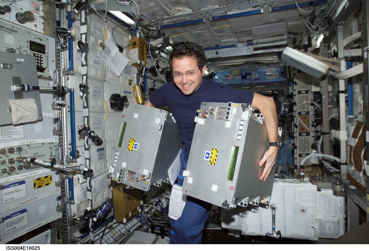 ISS004-E-10025 (12 April 2002) --- Astronaut Daniel W. Bursch, Expedition Four flight engineer, moves equipment in the Destiny laboratory on the International Space Station (ISS).