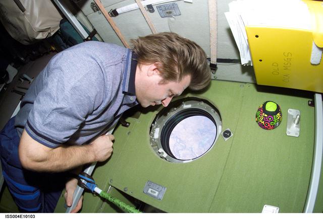 NASA image: Onyfrienko looks through a window in the Zvezda SM during Expedition Four