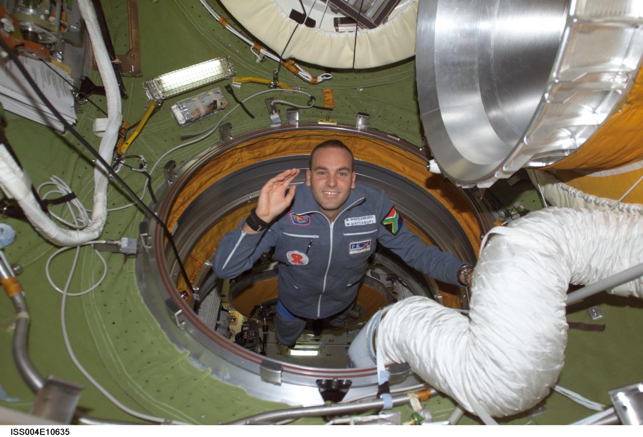 ISS004-E-10635 (27 April 2002) --- South African space flight participant Mark Shuttleworth enters the functional cargo block&#0146;s (FGB) pressurized adapter on the International Space Station (ISS). Shuttleworth and his Soyuz Taxi crewmates, Commander Yuri Gidzenko and Flight Engineer Roberto Vittori of the European Space Agency (ESA), arrived at the orbital outpost on April 27, 2002 at 2:56 a.m. (CDT) as the two vehicles flew over Central Asia.
