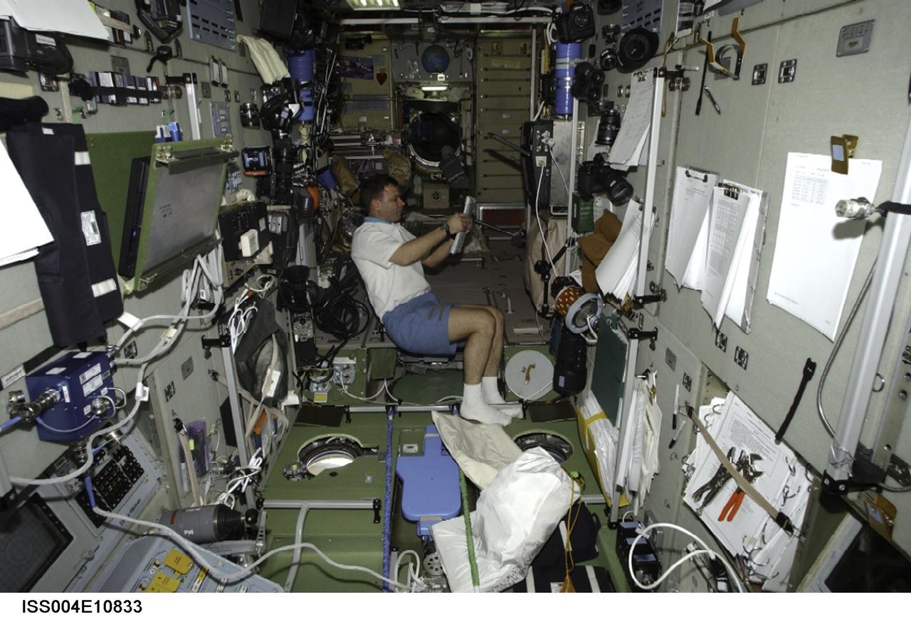 ISS004-E-10833 (May 2002) --- Cosmonaut Yuri Gidzenko, Soyuz Taxi Commander representing Rosaviakosmos, works in the Zvezda Service Module on the International Space Station (ISS). Gidzenko, who is making his third flight into space, is the first former resident of the ISS to return to the complex, having been a member of the Expedition One crew, the first crew to live aboard the station.