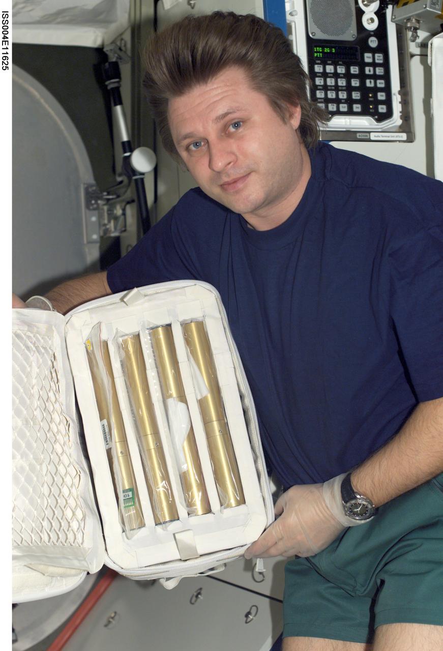 ISS004-E-11625 (10 May 2002) --- Cosmonaut Yury I. Onufrienko, Expedition Four mission commander, holds a stowage bag containing autoclave units in the Destiny laboratory on the International Space Station (ISS). Onufrienko represents Rosaviakosmos.