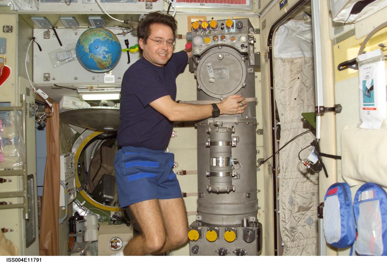 ISS004-E-11791 (26 April 2002) --- Astronaut Daniel W. Bursch, Expedition Four flight engineer, works on the Elektron Oxygen Generator in the Zvezda Service Module on the International Space Station (ISS).