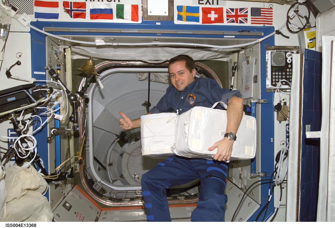 ISS004-E-13368 (June 2002) --- Astronaut Daniel W. Bursch, Expedition Four flight engineer, holds stowage containers in the Destiny laboratory on the International Space Station (ISS).
