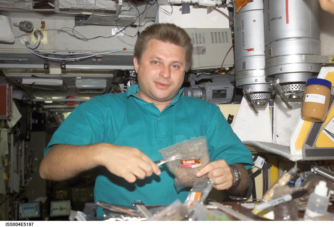 ISS004-E-5197 (December 2001) --- Cosmonaut Yuri I. Onufrienko, Expedition Four mission commander, prepares a meal in the Zvezda Service Module on the International Space Station (ISS). Onufrienko represents Rosaviakosmos. The image was taken with a digital still camera.