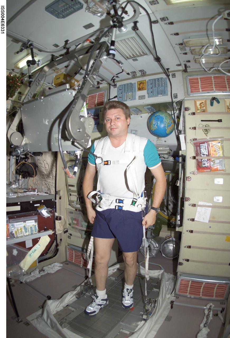 ISS004-E-6331 (January 2002) --- Cosmonaut Yury I. Onufrienko, Expedition Four mission commander representing Rosaviakosmos, exercises on a treadmill in the Zvezda Service Module on the International Space Station (ISS). The image was taken with a digital still camera.