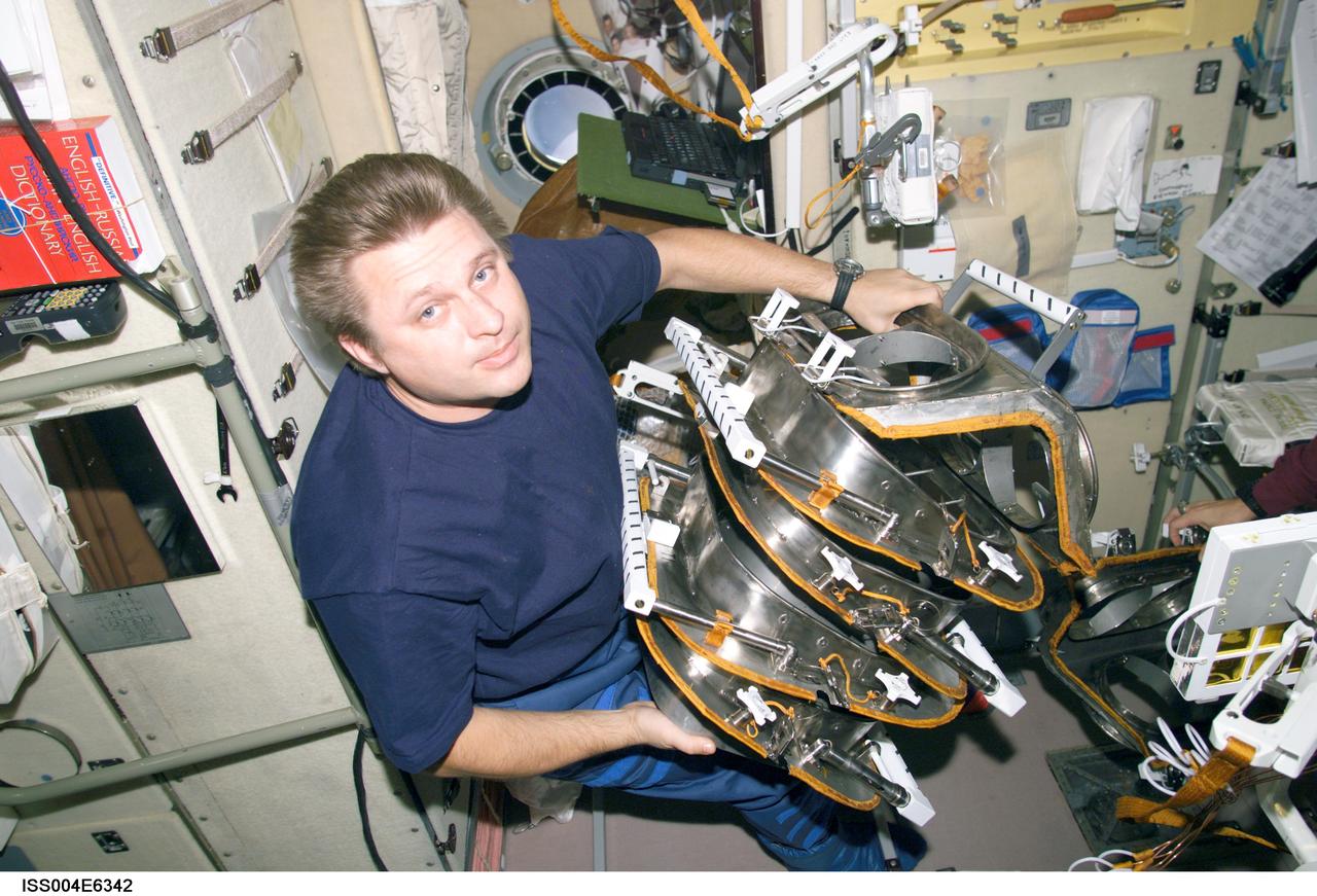 ISS004-E-6342 (January 2002) --- Cosmonaut Yury I. Onufrienko, Expedition Four mission commander representing Rosaviakosmos, works with equipment in the Zvezda Service Module on the International Space Station (ISS). The image was taken with a digital still camera.