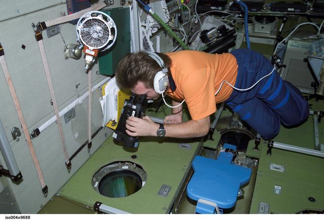 NASA image: Onufrienko uses binoculars to look out SM window during Expedition Four