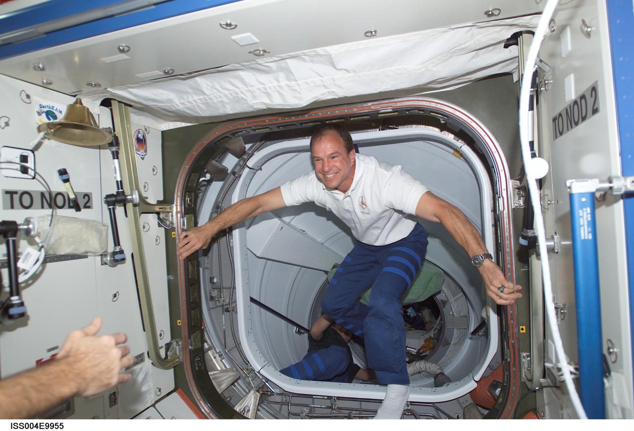 ISS004-E-9955 (10 April 2002) --- Astronaut Michael J. Bloomfield, STS-110 mission commander, steps into the Destiny laboratory on the International Space Station (ISS) through the Pressurized Mating Adapter 2 (PMA-2) upon docking of the Space Shuttle Atlantis and the station.