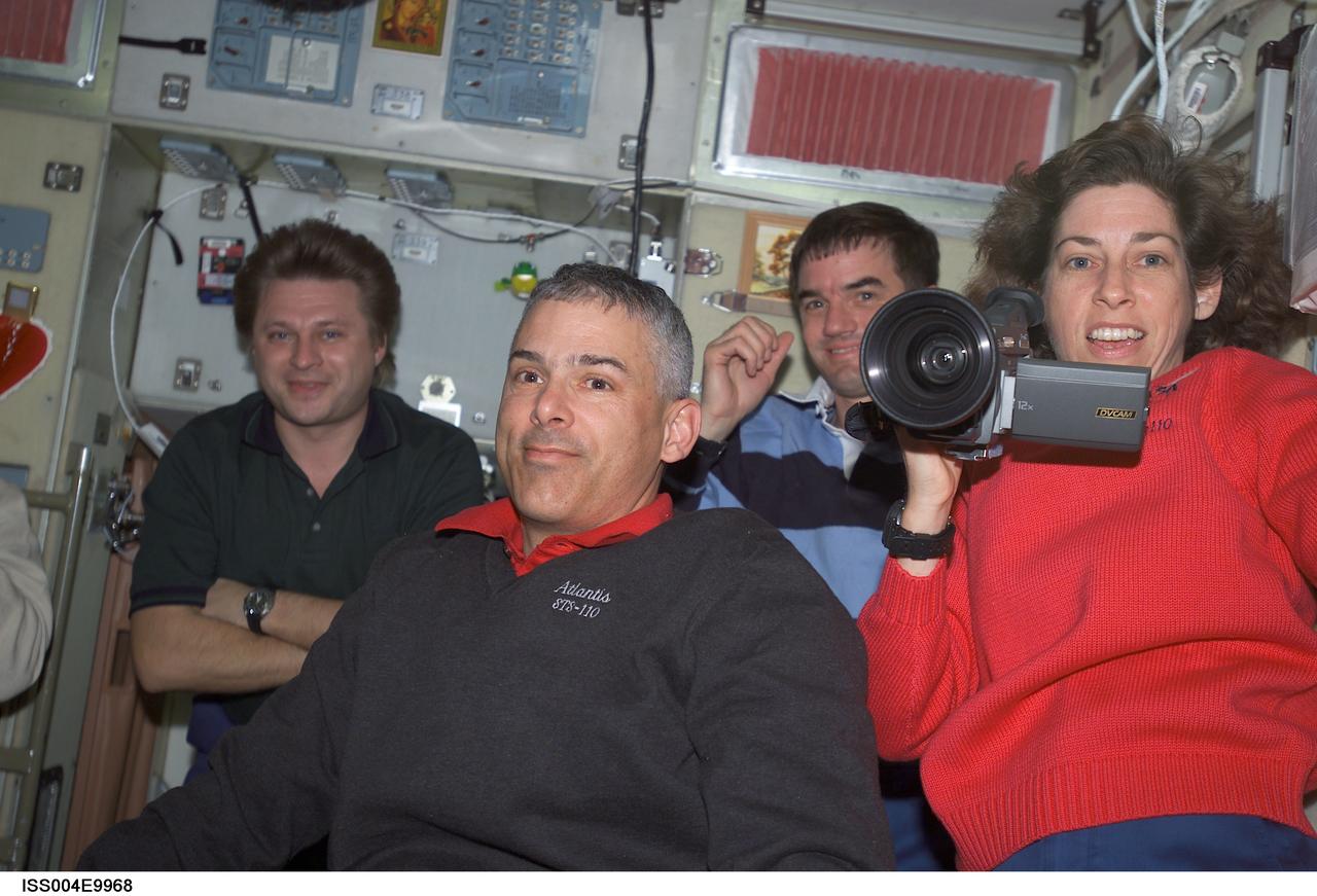 ISS004-E-9968 (10 April 2002) --- Astronauts Lee M. E. Morin (left foreground) and Ellen Ochoa, both STS-110 mission specialists, cosmonaut Yury I. Onufrienko (left background), Expedition Four mission commander, and astronaut Rex J. Walheim, STS-110 mission specialist, are photographed in the Zvezda Service Module on the International Space Station (ISS).