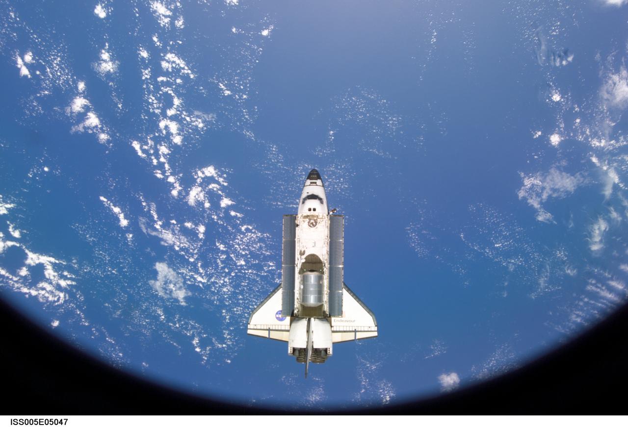 ISS005-E-05047 (15 June 2002) --- As seen through a window on the International Space Station (ISS), the Space Shuttle Endeavour is photographed shortly after its separation from the station. The undocking occurred at 9:32 a.m. (CDT) on June 15, 2002.