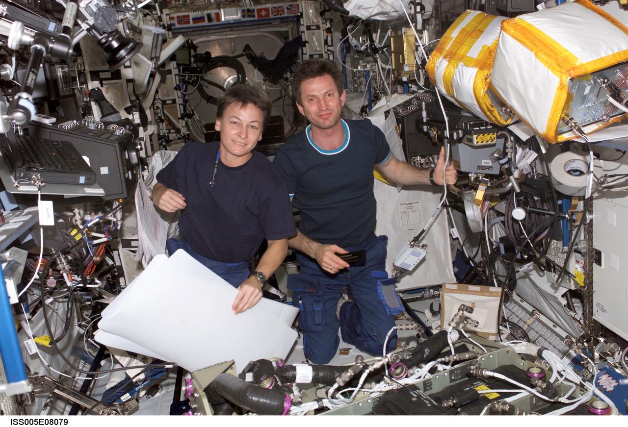 ISS005-E-08079 (July 2002) --- Astronaut Peggy A. Whitson (left) and cosmonaut Sergei Y. Treschev, both Expedition Five flight engineers, work in the Destiny laboratory on the International Space Station (ISS). Treschev represents Rosaviakosmos.