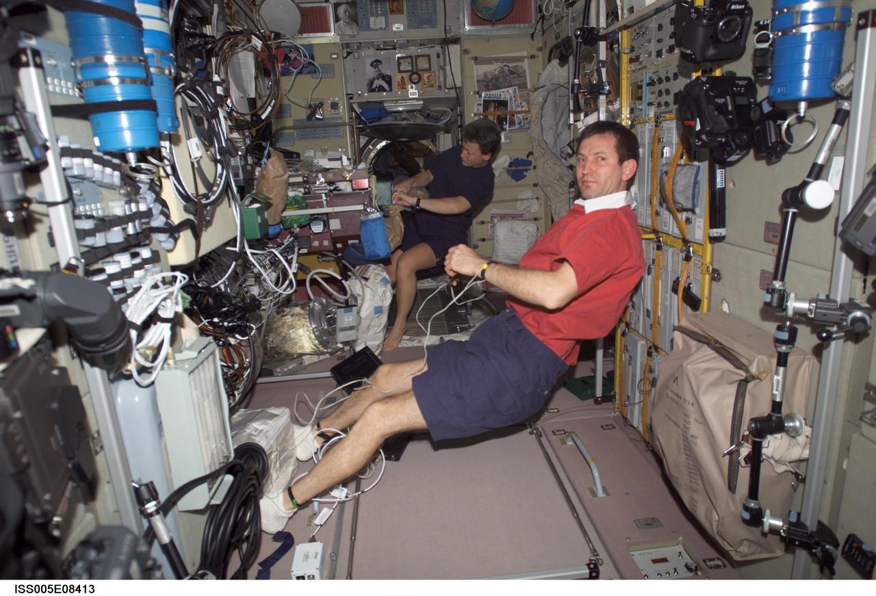 ISS005-E-08413 (July 2002) --- Cosmonaut Sergei Y. Treschev (foreground) and astronaut Peggy A. Whitson, both Expedition Five flight engineers, are photographed in the Zvezda Service Module on the International Space Station (ISS). Treschev represents Rosaviakosmos.