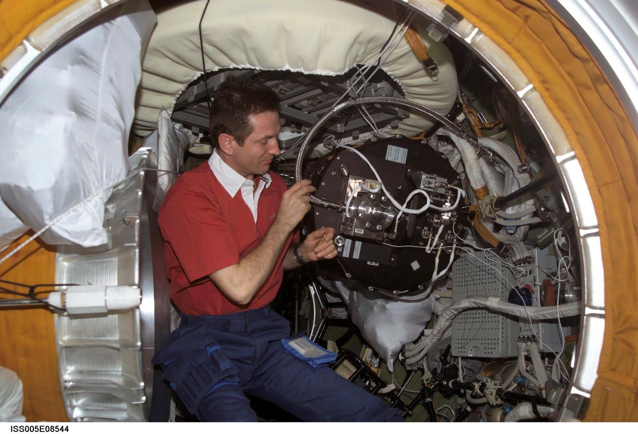 ISS005-E-08544 (3 August 2002) --- Cosmonaut Sergei Y. Treschev, Expedition Five flight engineer, disassembles the Plasmakristall Telescience Apparatus in the Zvezda Service Module’s transfer compartment on the International Space Station (ISS). Treschev represents Rosaviakosmos.